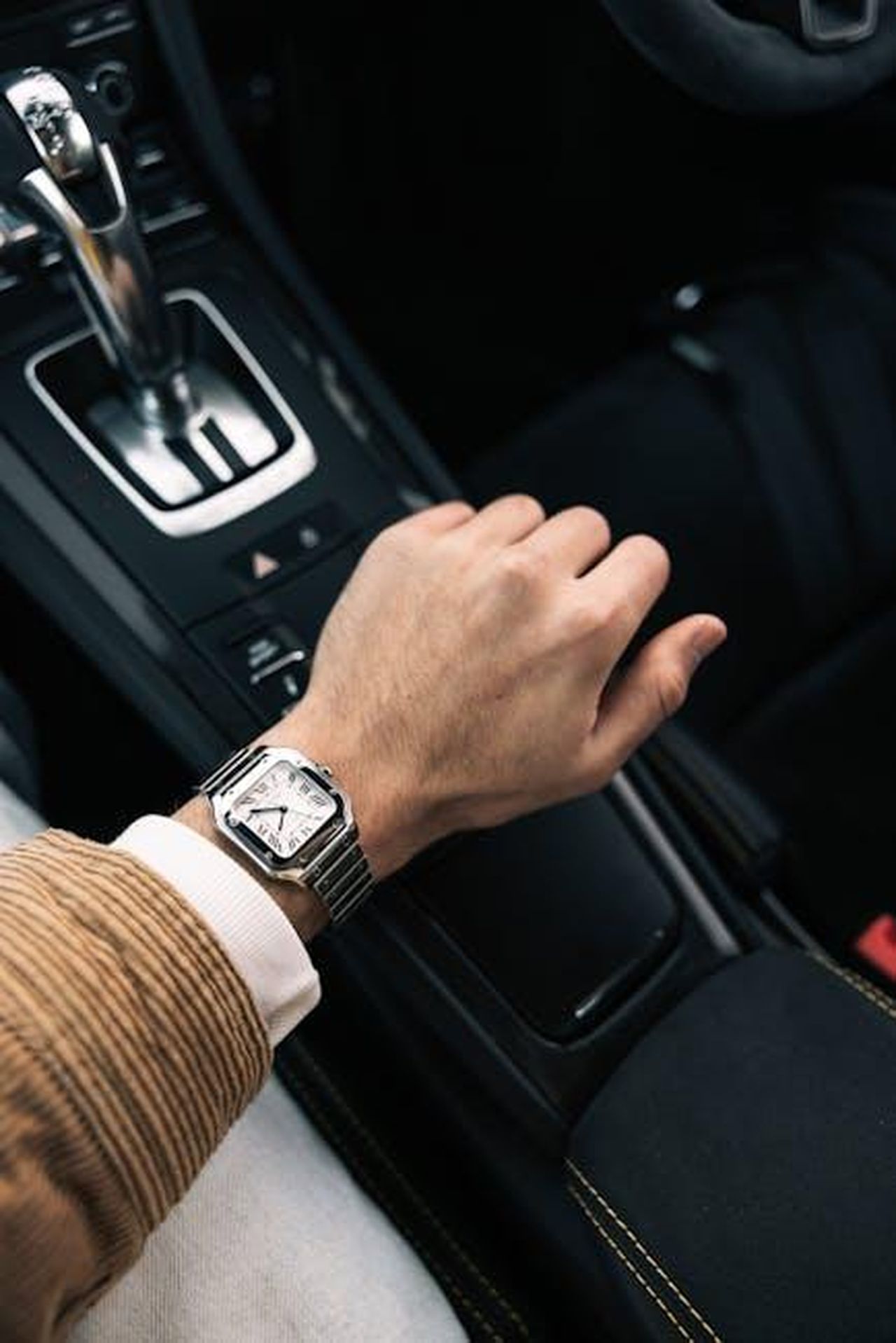 Trasmissione_a_due_velocit_XHF5oESReG - Veicoli24 Source: Stephan Louis - pexels - A man's hand with a luxury watch rests on the gearshift of a luxury car, highlighting elegance and style.