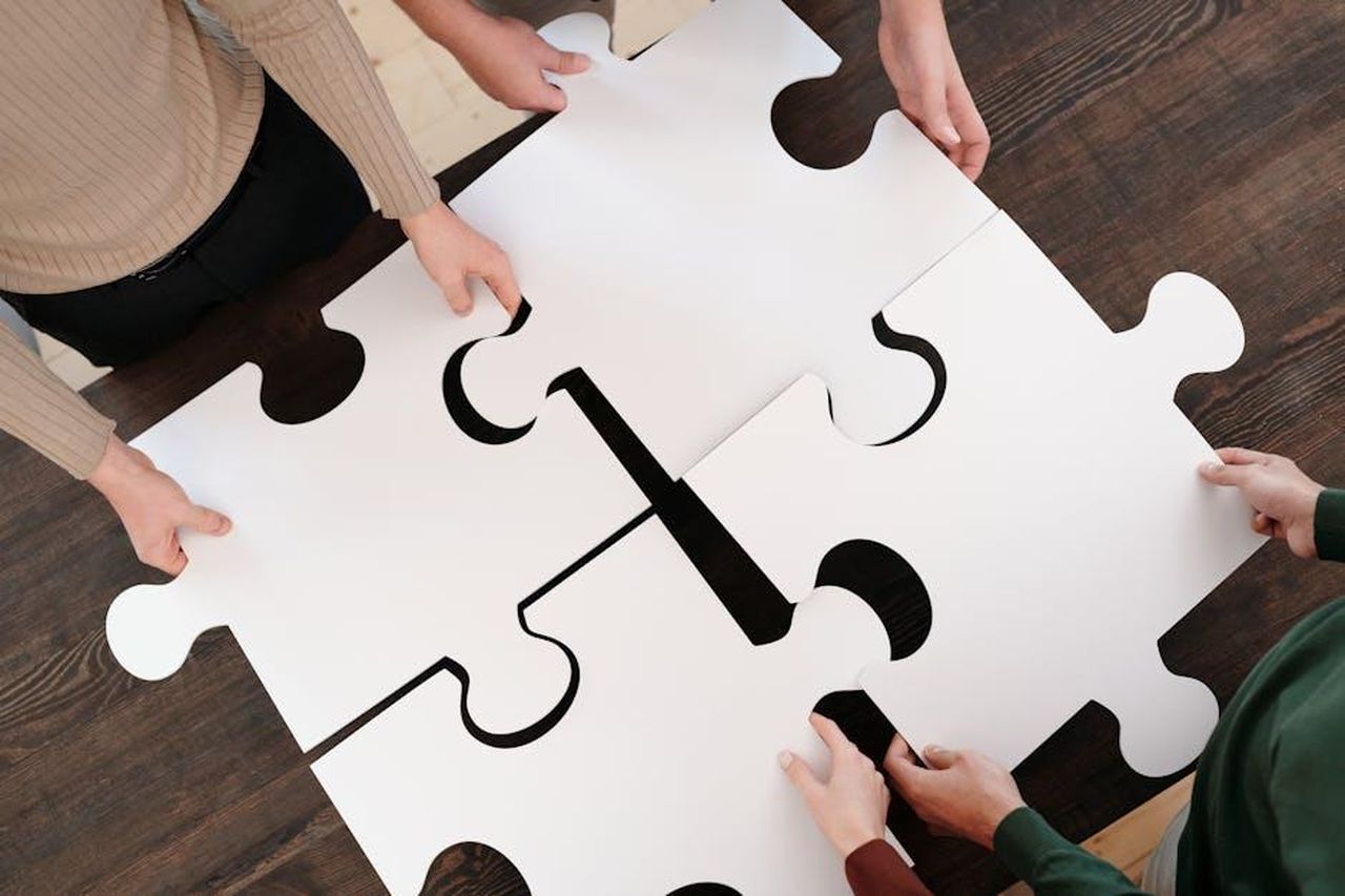 Una_soluzione_integrata_IxGknoiBUN - Veicoli24 Source: Diva Plavalaguna - pexels - Group collaborating on assembling large puzzle pieces symbolizing teamwork and unity.