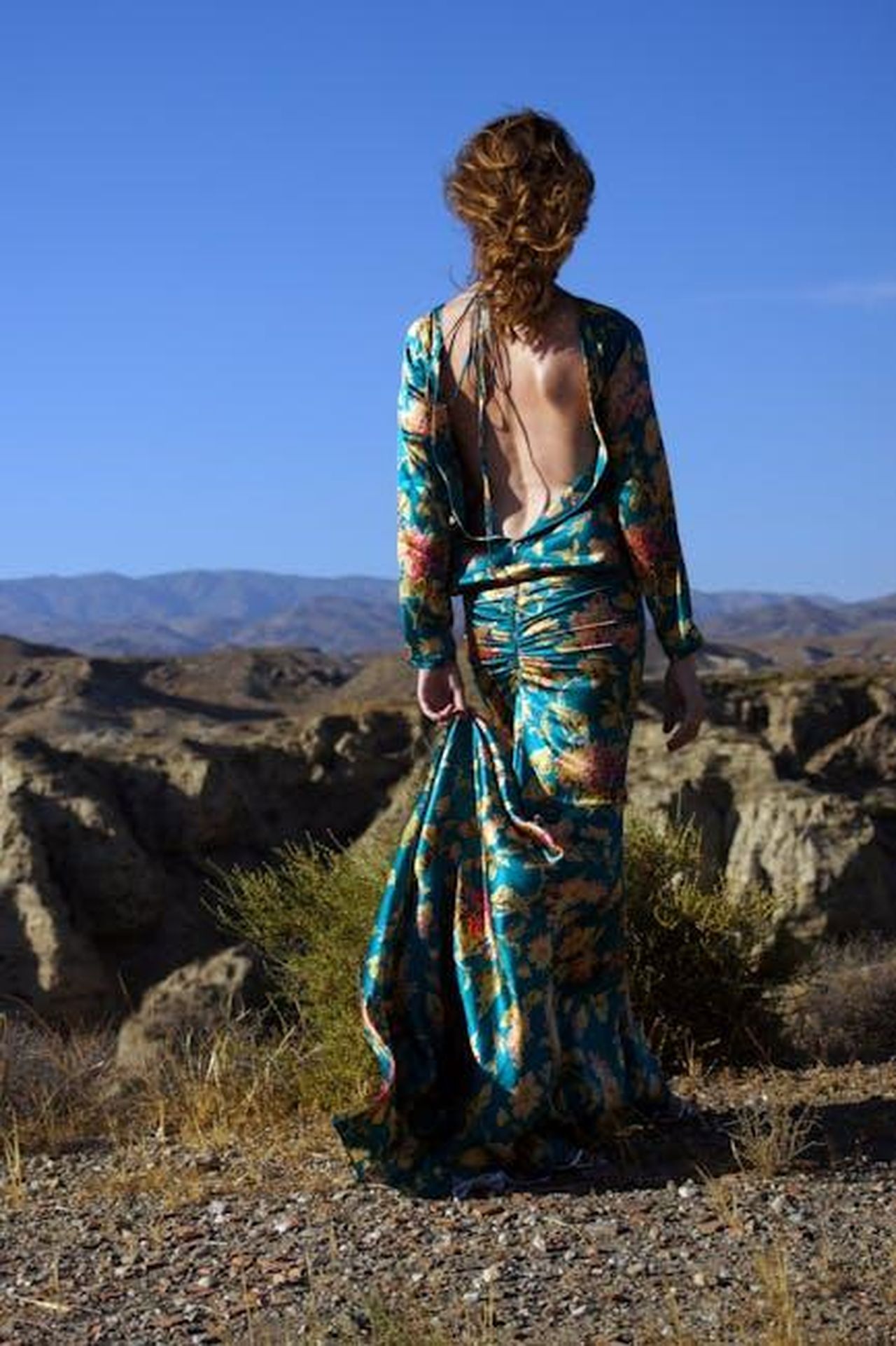 Viaggio_nel_deserto_di_Almeria_in_Spagna_CAeF9m8Jn0 - Veicoli24 Source: Rodrigo - pexels - Back view of woman in floral dress exploring Almería desert landscape.