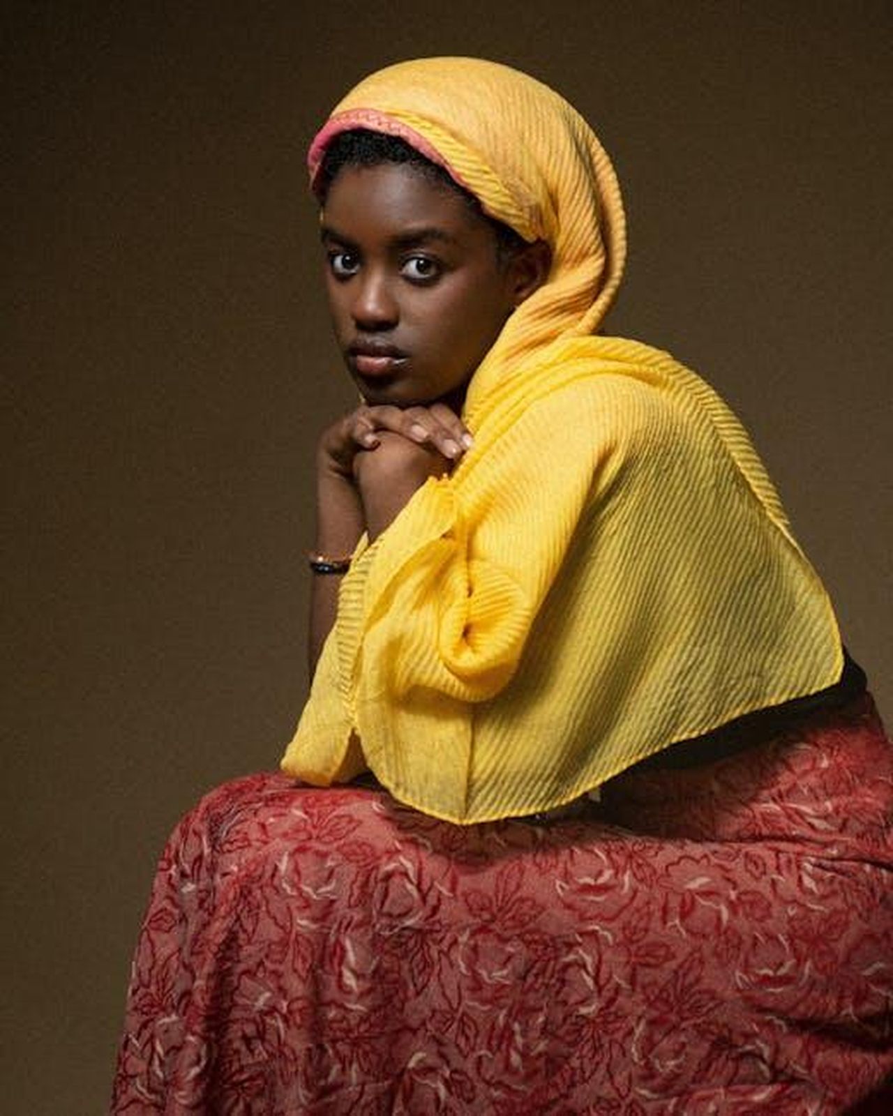 Collettivo_Africano_di_Film_e_Arti_Mediali_stazioni_e_artisti_uubcdrjqJh - Veicoli24 Source: Ante Emmanuel - pexels - Portrait of a woman in a yellow hijab and red patterned dress looking thoughtfully.