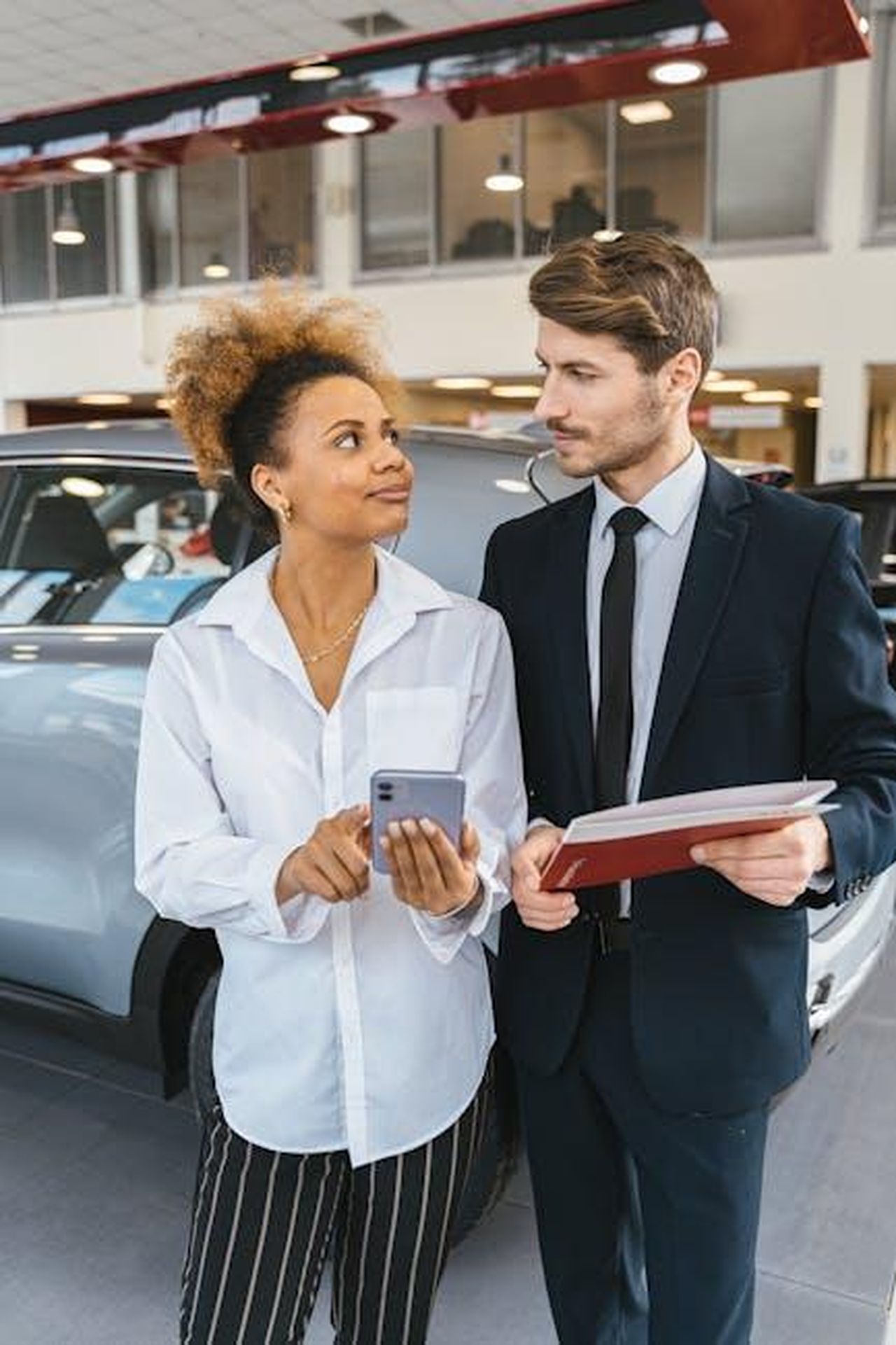 Crescita_delle_immatricolazioni_e_quota_di_mercato_ZpZxqp2KVI - Veicoli24 Source: Antoni Shkraba - pexels - A business professional discussing details inside a car showroom