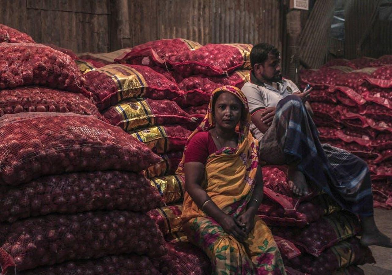 Divisione_Lexus_Vendite_di_marzo_e_primo_trimestre_Kd3CXhWvY9 - Veicoli24 Source: Sadid Morshed - pexels - A man and woman sit among sacks of onions in a market in Dhaka, Bangladesh, captured in a candid moment.
