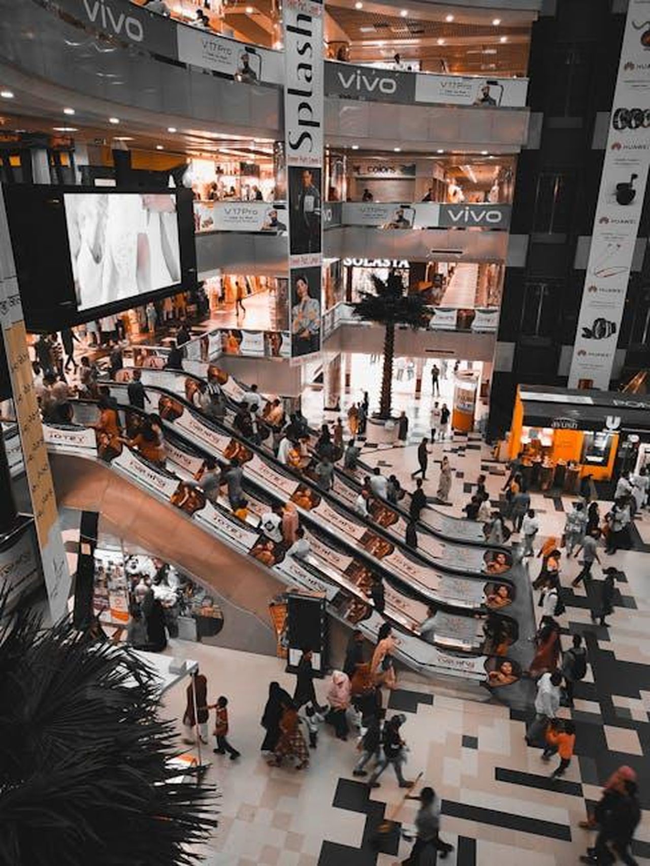 Divisione_Toyota_Vendite_di_marzo_e_primo_trimestre_tMjopsrAEY - Veicoli24 Source: Falak SabbirBRO Photography - pexels - A busy shopping mall in Dhaka with crowds and escalators, showcasing retail vibrancy.
