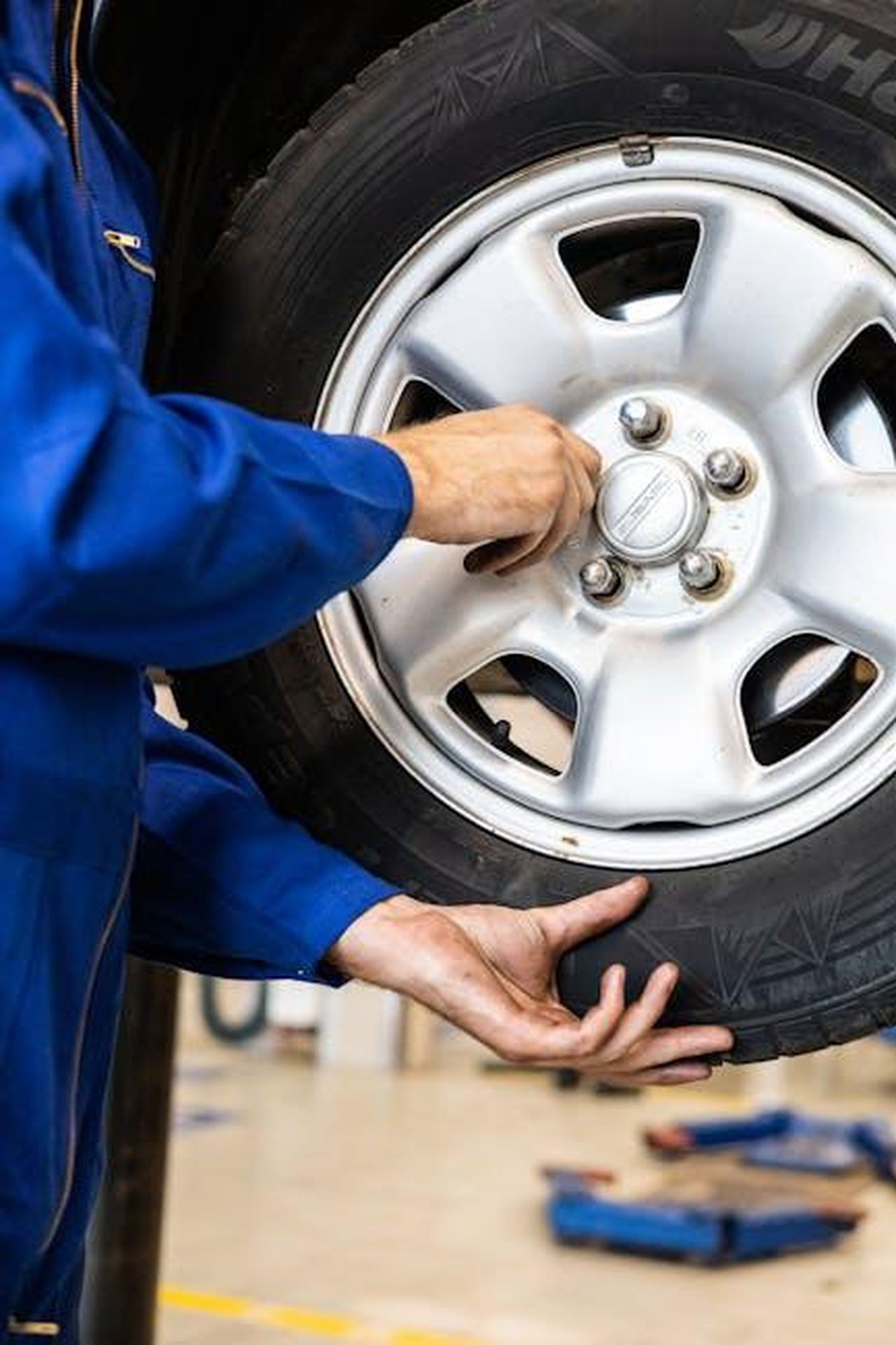 Garanzia_Limitata_Toyota_jYVn1vxUUZ - Veicoli24 Source: Artem Podrez - pexels - A mechanic tightens bolts on a car wheel in a professional garage setting.