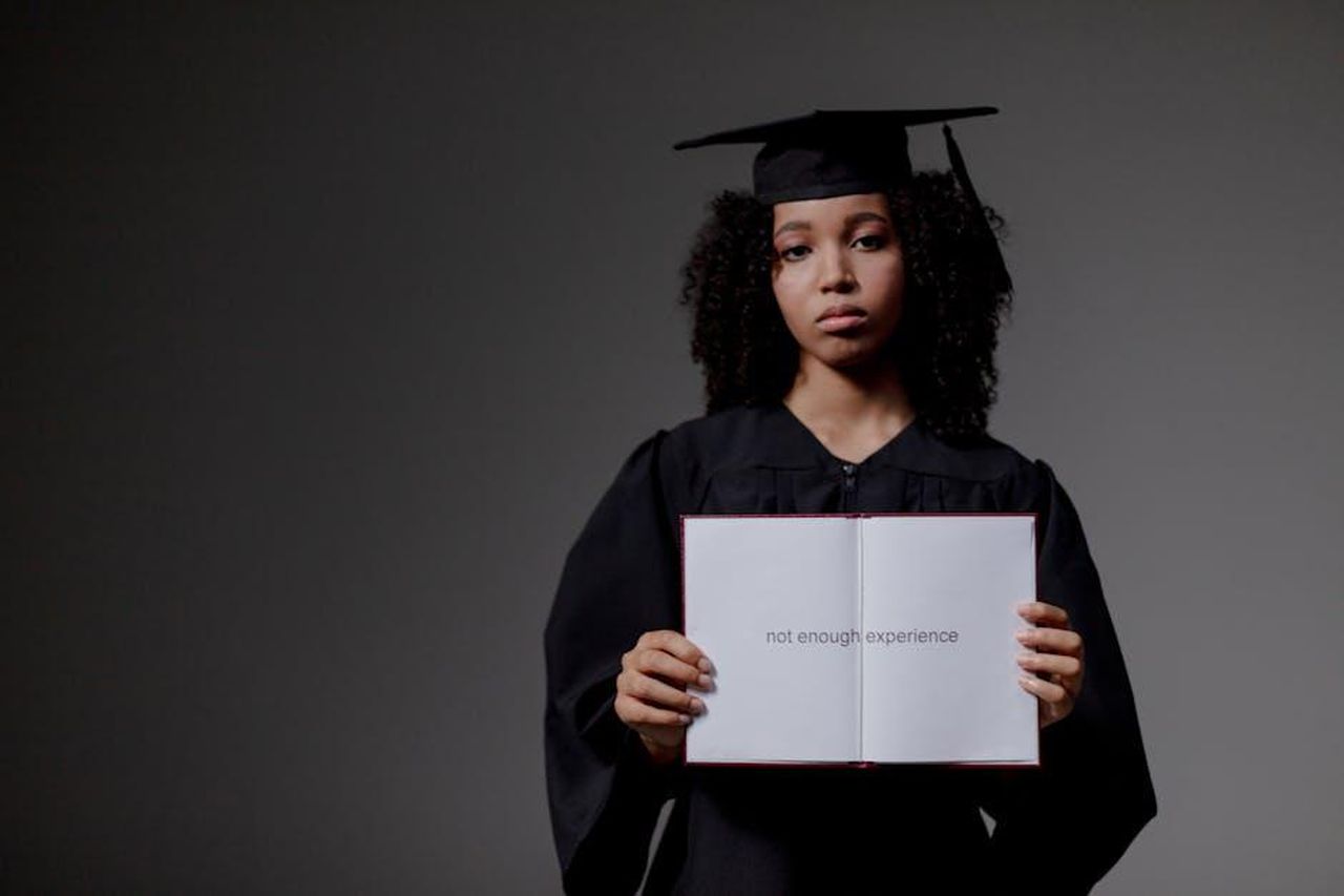 Obiettivi_del_programma_I_drive_MercedesBenz_9L9ruSkEdw - Veicoli24 Source: Ron Lach - pexels - Young graduate holding a book with 'not enough experience' message, symbolizing job hunt difficulties.