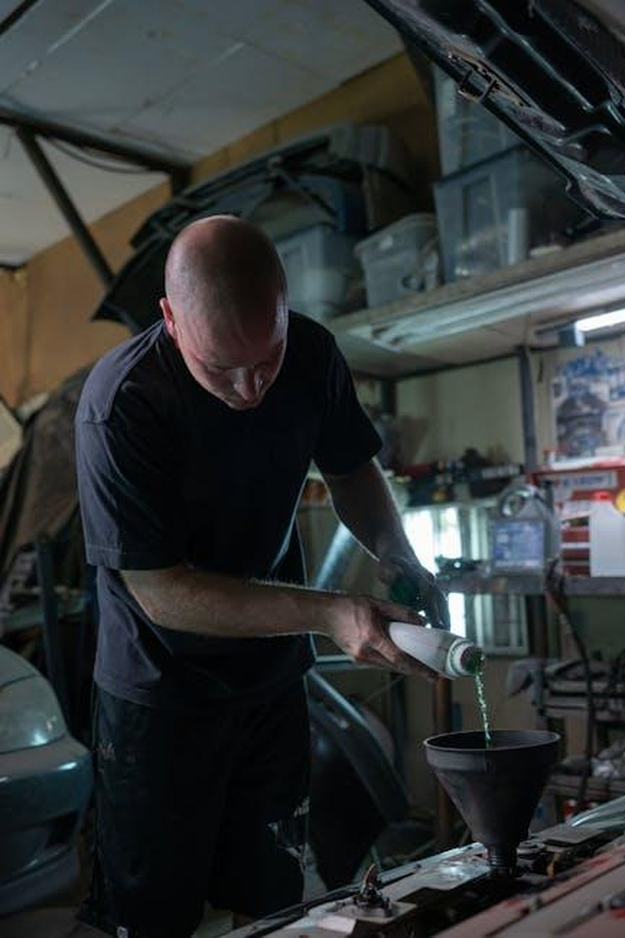 Produzione_della_N8_nello_stabilimento_Stellantis_di_Melfi_T4c2J1OQos - Veicoli24 Source: Anastasia Shuraeva - pexels - Man pours engine fluid into a vehicle in a dimly lit garage.