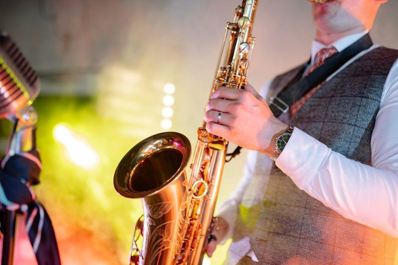 Repertorio_e_influenze_musicali_XhhMkVxxJ7 - Veicoli24 Source: Yan Krukau - pexels - A musician passionately playing the saxophone, showcasing talent under colorful stage lights.