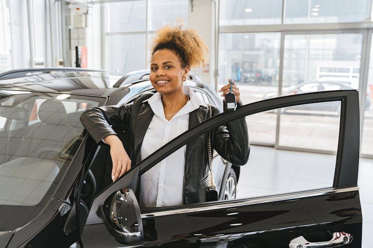 Trend_positivo_nel_cumulato_trimestrale_Y0wyJ07OBE - Veicoli24 Source: Antoni Shkraba - pexels - Smiling woman holding car key in dealership showroom next to new vehicle.